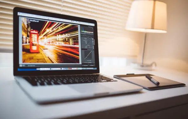 Schermo di computer con editor di immagini aperto su una scrivania