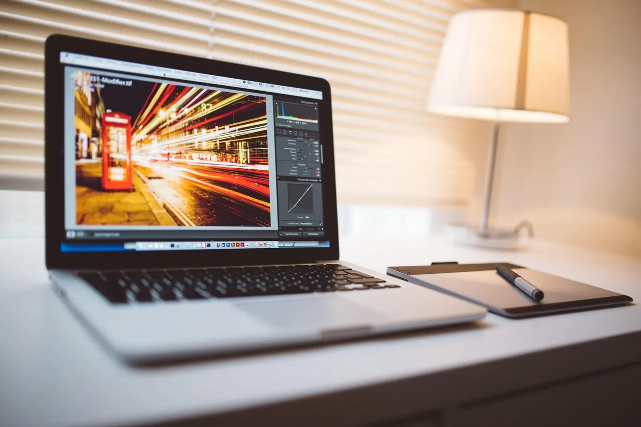 Schermo di computer con editor di immagini aperto su una scrivania