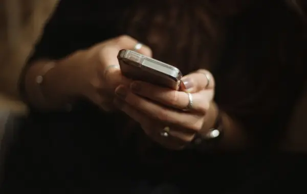 Persona che usa uno smartphone per una conversazione in chat