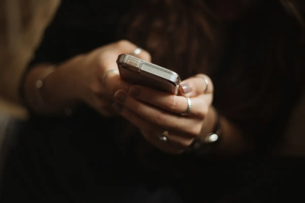 Persona che usa uno smartphone per una conversazione in chat