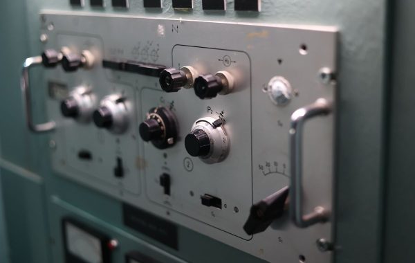 Sala di controllo con monitor e operatori, simbolo di sicurezza e ridondanza