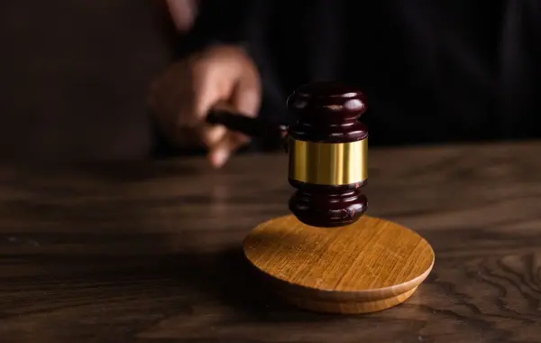Martelletto da giudice su un tavolo, simbolo di indagine e regolamentazione