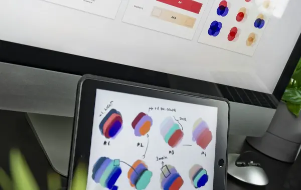 Scrivania di un designer con schizzi e strumenti per creare un logo