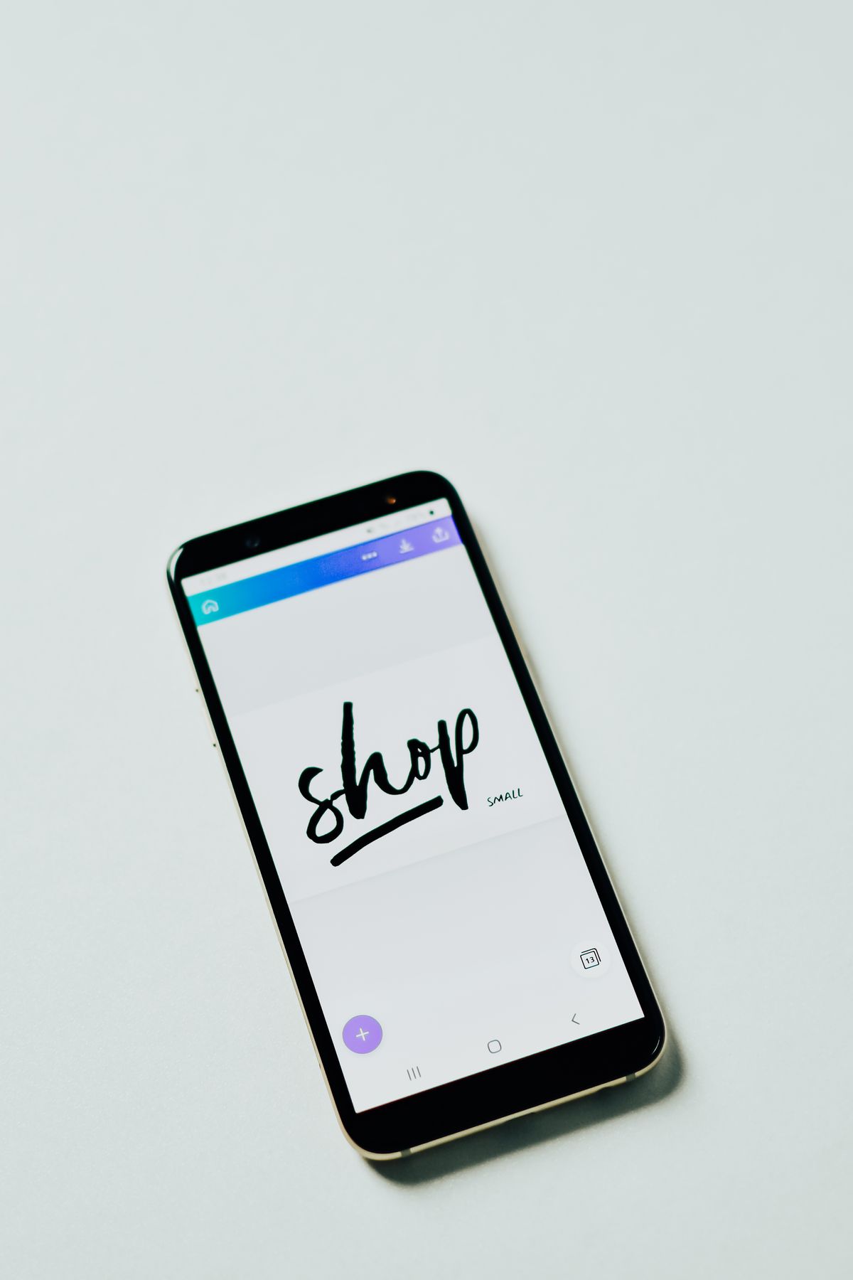 Smartphone con app di shopping online su una superficie bianca