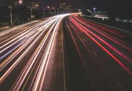 Scie luminose di auto in movimento di notte, immagine che richiama la velocità di inferenza