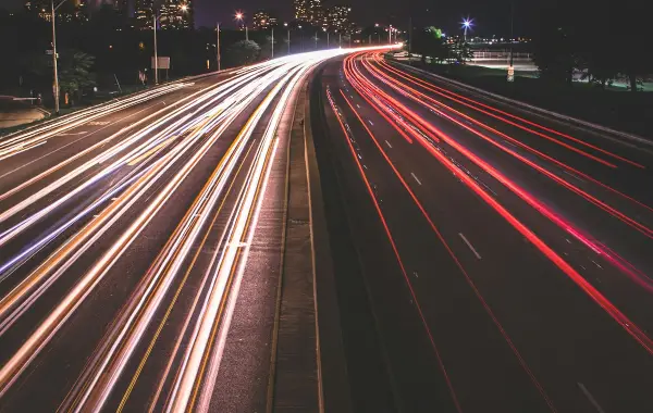Scie luminose di auto in movimento di notte, immagine che richiama la velocità di inferenza
