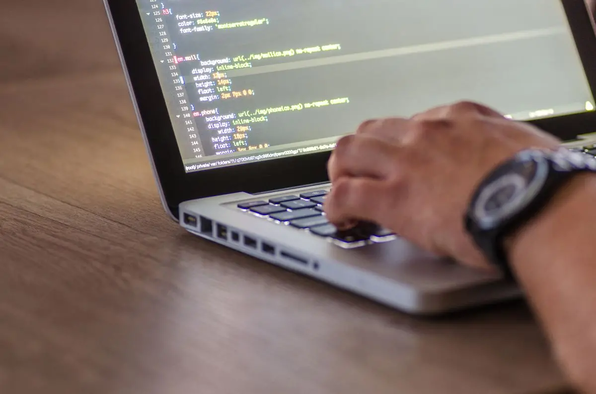 Sviluppatore al lavoro sul codice davanti a un laptop