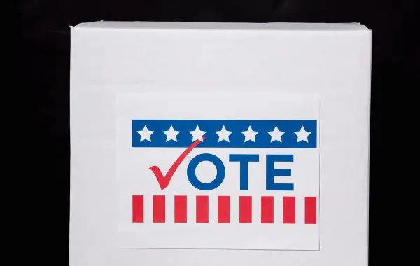 Elettore che inserisce la scheda nell'urna durante il voto