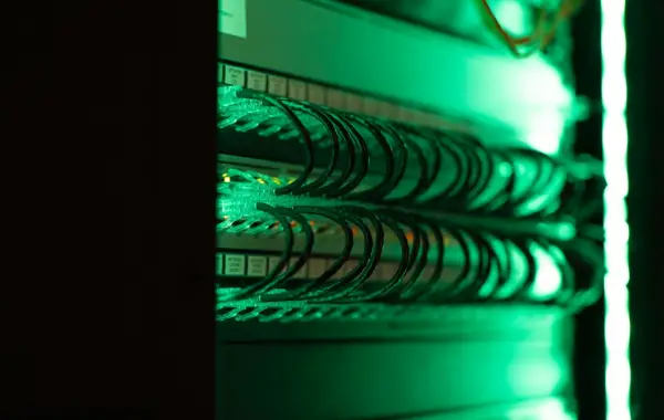 Corridoio di una server room con cavi e rack illuminati