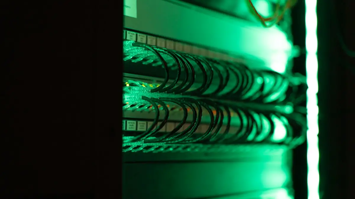 Corridoio di una server room con cavi e rack illuminati