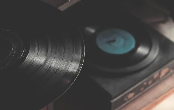 Disco in vinile su un giradischi, simbolo della causa sui diritti musicali contro le AI
