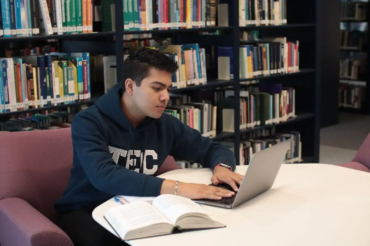 Laptop aperto su una scrivania con appunti e quaderno per studiare