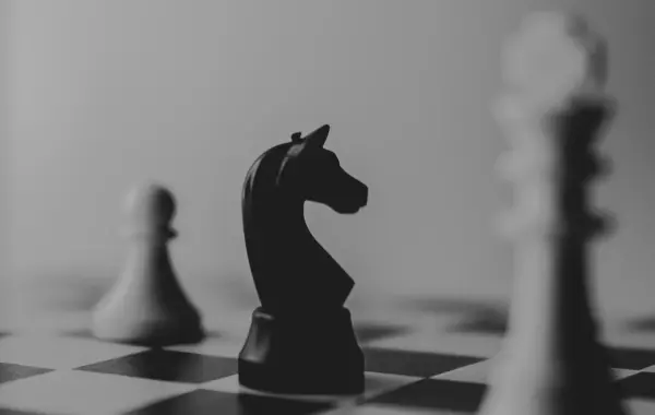 Pezzi degli scacchi su una scacchiera, simbolo del ragionamento e della strategia