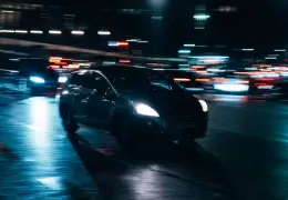 Auto in movimento di notte tra le luci della città