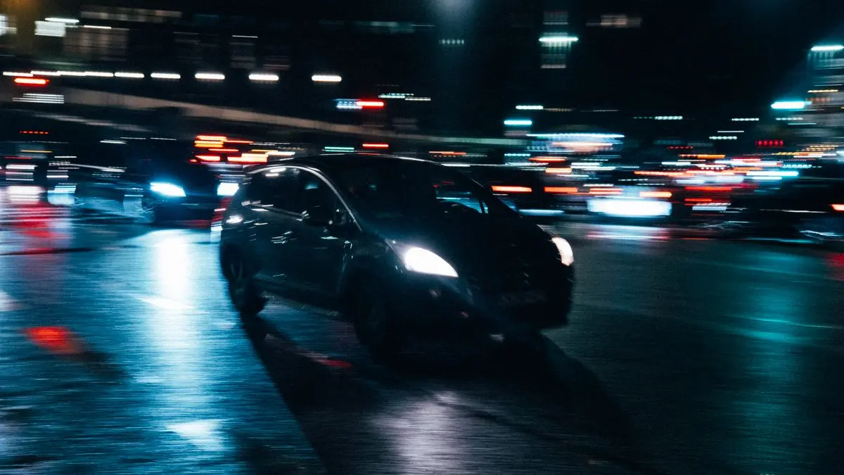 Auto in movimento di notte tra le luci della città